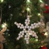 Décoration de noël en bois pour le sapin en forme de flocon de neige accrochée sur le sapin