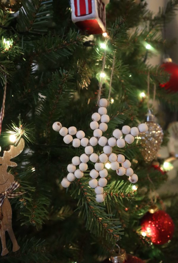 Décoration de noël en bois pour le sapin en forme de flocon de neige accrochée sur le sapin