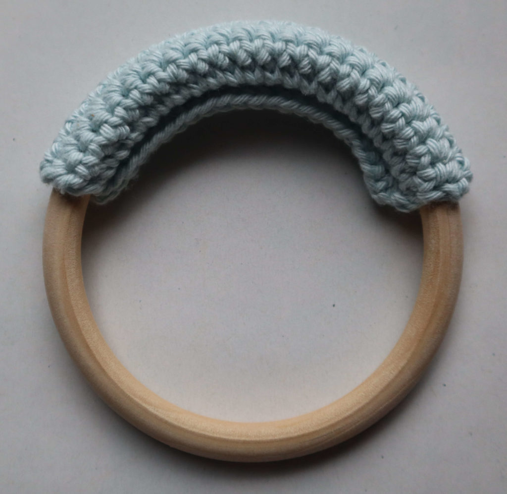 L'anneau en bois pour hochet lapin au crochet de couleur bleu clair